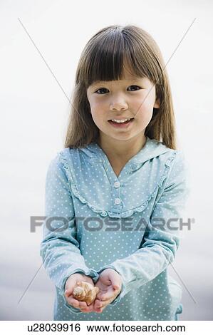 Young girl holding seashell View Large Photo Image Stock Photograph - Young girl holding seashell. Fotosearch