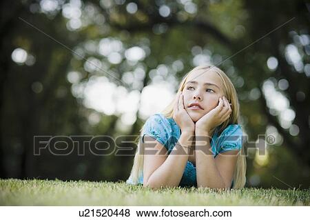 Young girl lying on grass View Large Photo Image Stock Photo - Young girl lying on grass. Fotosearch