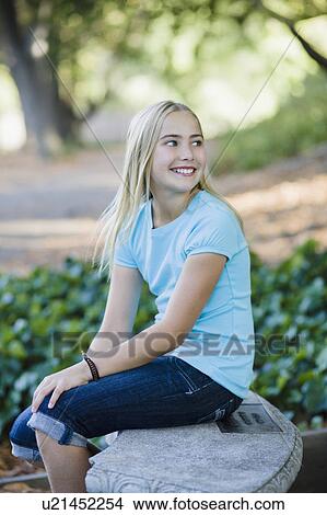 Picture - Young girl sitting on bench. Fotosearch