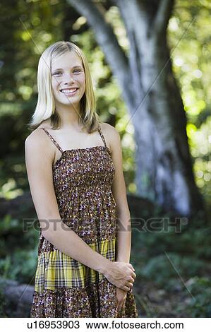Stock Image - Young girl standing outside. Fotosearch