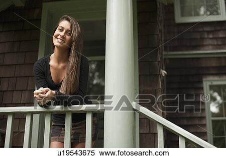 Stock Photography - Young woman leaning on banister. Fotosearch