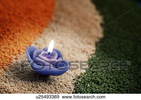 A candle in the middle of coloured pulses View Large Photo Image Stock Photo - A candle in the middle of coloured pulses. Fotosearch
