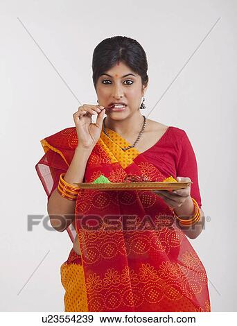 Stock Photo - A Rajasthani woman eating a red chilli. Fotosearch