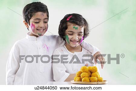 Boy and girl looking at laddoos View Large Photo Image Stock Image - Boy and girl looking at laddoos. Fotosearch