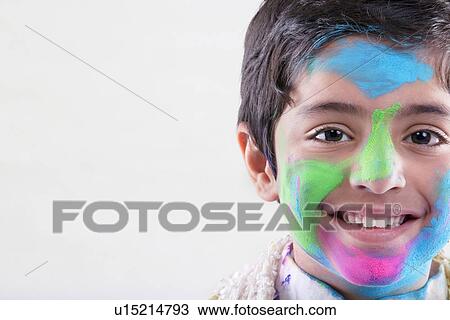 Stock Image - Boy with holi colours on his face. Fotosearch