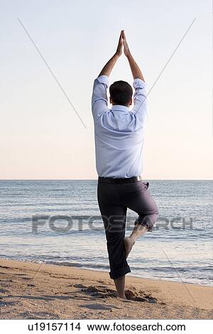 Businessman doing yoga on the beach View Large Photo Image Picture - Businessman doing yoga on the beach. Fotosearch