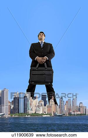 Stock Photo - Businessman standing over the city. Fotosearch