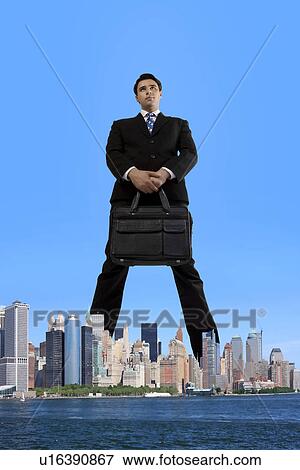 Stock Photo - Businessman standing over the city. Fotosearch