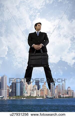 Stock Photograph - Businessman standing over the city. Fotosearch