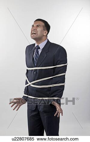 Stock Photography - Businessman tied up with rope. Fotosearch