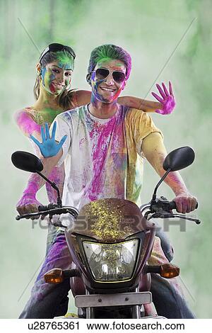 Couple on a motorcycle covered with colours View Large Photo Image Stock Image - Couple on a motorcycle covered with colours. Fotosearch