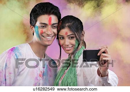 Couple taking a photograph of themselves View Large Photo Image Stock Photo - Couple taking a photograph of themselves. Fotosearch