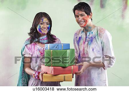 Couple with gifts on holi View Large Photo Image Stock Photo - Couple with gifts on holi. Fotosearch