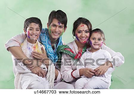 Stock Image - Family posing after playing holi. Fotosearch