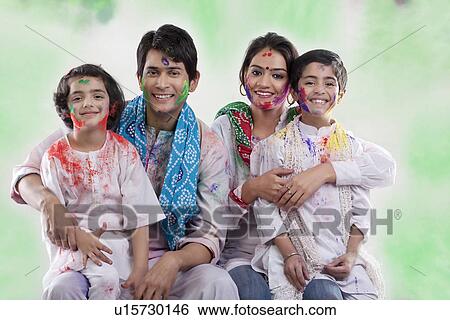 Stock Photograph - Family posing after playing holi. Fotosearch