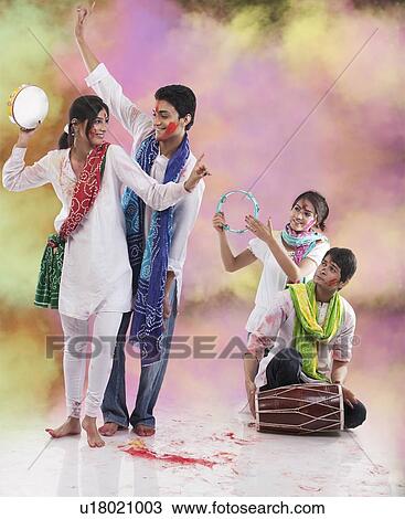 Stock Image - Friends enjoying Holi. Fotosearch