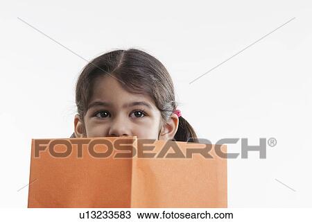 Girl covers half of her face with a book View Large Photo Image Stock Image - Girl covers half of her face with a book. Fotosearch