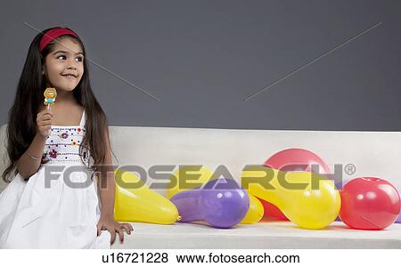 Girl having a lollipop View Large Photo Image Stock Photo - Girl having a lollipop. Fotosearch