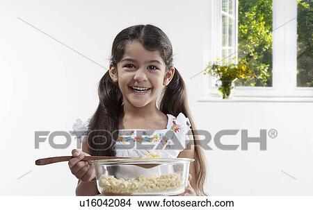 Picture - Girl holding a bowl and spatula. Fotosearch