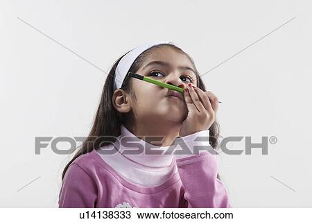 Girl holding a pencil between her lips and nose View Large Photo Image Stock Image - Girl holding a pencil between her lips and nose. Fotosearch