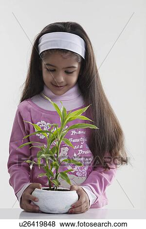 Stock Photo - Girl holding a potted plant. Fotosearch