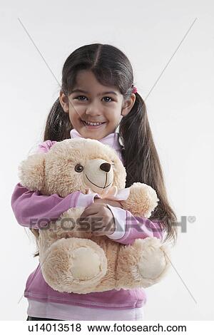 Stock Photo - Girl holding a teddy bear. Fotosearch