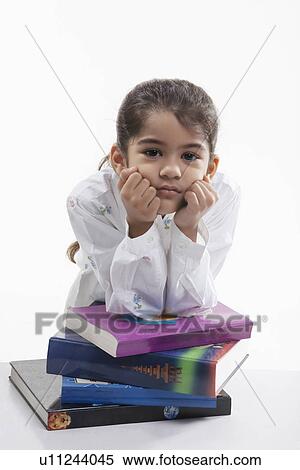 Girl leaning on a stack of books View Large Photo Image Stock Photography - Girl leaning on a stack of books. Fotosearch