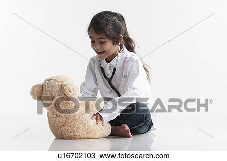 Girl playing doctor with teddy bear View Large Photo Image Stock Image - Girl playing doctor with teddy bear. Fotosearch