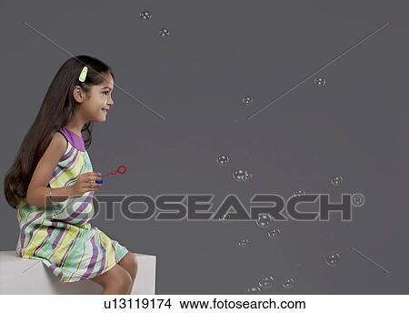 Picture - Girl playing with bubbles. Fotosearch