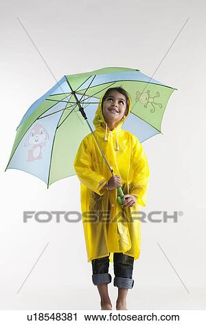 Girl wearing a raincoat and holding an umbrella View Large Photo Image Stock Image - Girl wearing a raincoat and holding an umbrella. Fotosearch