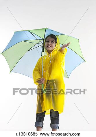 Stock Photography - Girl wearing a raincoat and holding an umbrella. Fotosearch
