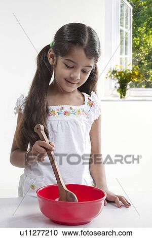 Stock Image - Girl with a spatula and a bowl. Fotosearch