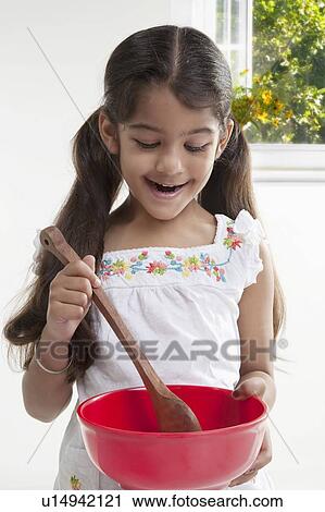 Stock Image - Girl with a spatula and a bowl. Fotosearch