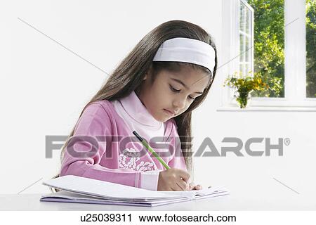Stock Image - Girl writing in a notebook. Fotosearch