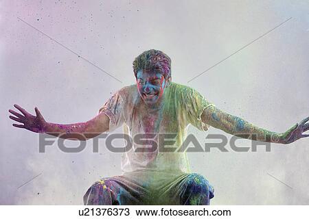 Stock Image - Man covered in holi colours. Fotosearch