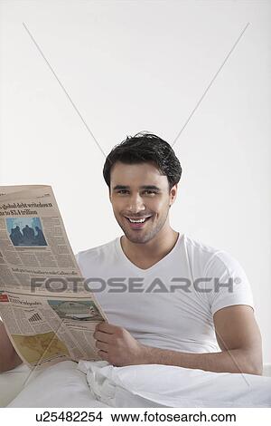 Man holding a newspaper View Large Photo Image Picture - Man holding a newspaper. Fotosearch