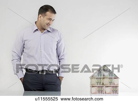 Stock Photography - Man looking at a house model. Fotosearch