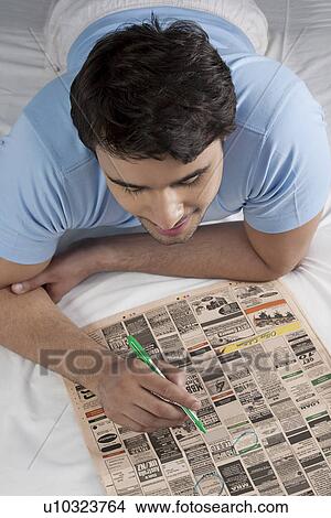Picture - Man looking for jobs in the newspaper. Fotosearch