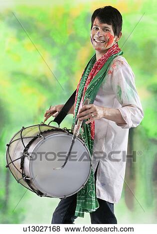 Stock Photo - Man playing on a dhol. Fotosearch