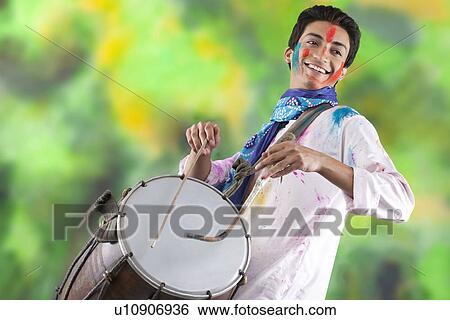 Stock Photograph - Man playing on a dhol. Fotosearch