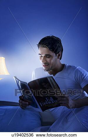 Stock Photograph - Man reading a magazine. Fotosearch