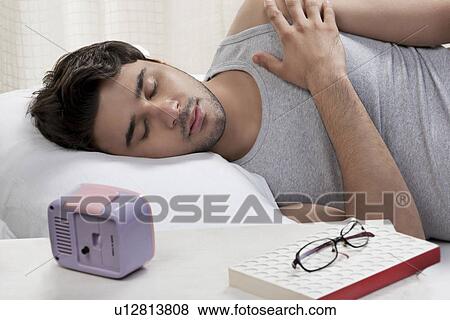 Stock Photo - Man sleeping in bed. Fotosearch
