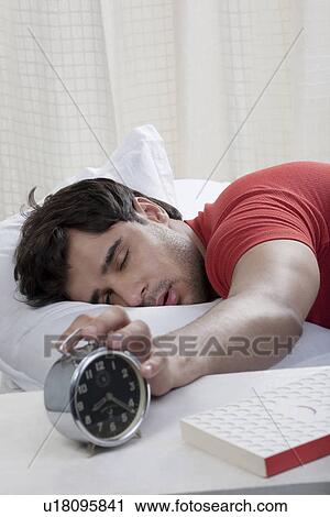 Man switching off his alarm clock View Large Photo Image Stock Image - Man switching off his alarm clock. Fotosearch