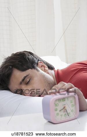 Man switching off his alarm clock View Large Photo Image Stock Image - Man switching off his alarm clock. Fotosearch