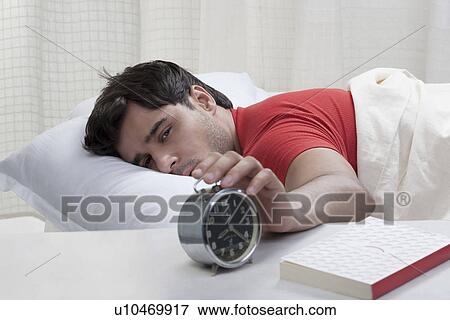 Man switching off his alarm clock View Large Photo Image Stock Photo - Man switching off his alarm clock. Fotosearch