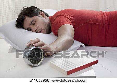 Man switching off his alarm clock View Large Photo Image Stock Photograph - Man switching off his alarm clock. Fotosearch