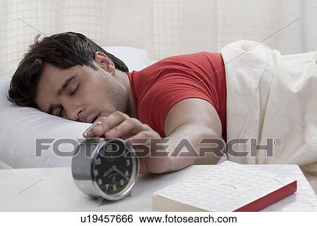 Man switching off his alarm clock View Large Photo Image Stock Photograph - Man switching off his alarm clock. Fotosearch
