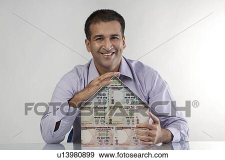 Man with a house model View Large Photo Image Stock Photo - Man with a house model. Fotosearch