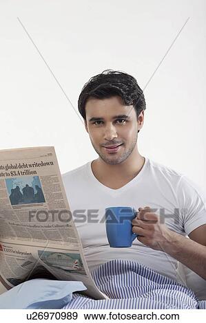 Stock Photo - Man with a newspaper and coffee. Fotosearch