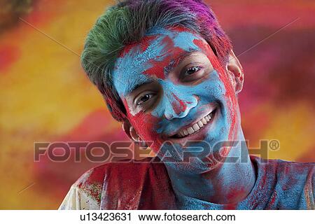 Stock Image - Man's face covered in holi colours. Fotosearch